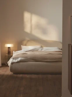 Cama tapizada redondeada en tejido bouclé Alba