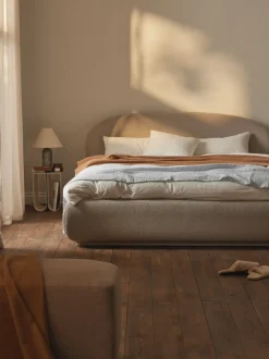 Cama tapizada redondeada en tejido bouclé Alba