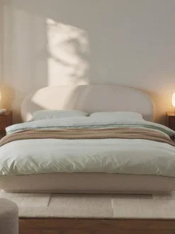 Cama tapizada redondeada en tejido bouclé Alba