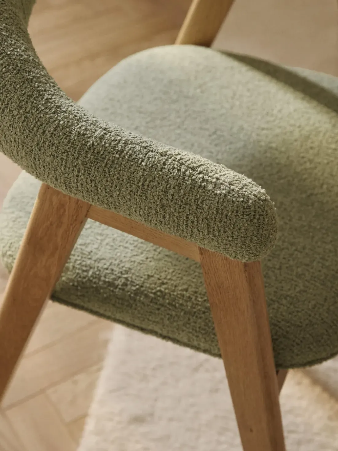 Silla con reposabrazos tapizada en tejido bouclé Nik